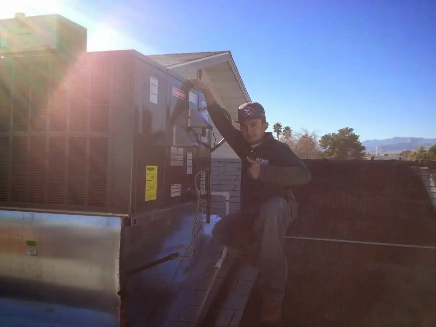 HVAC technician performing Boiler Repair on a rooftop unit in Garner